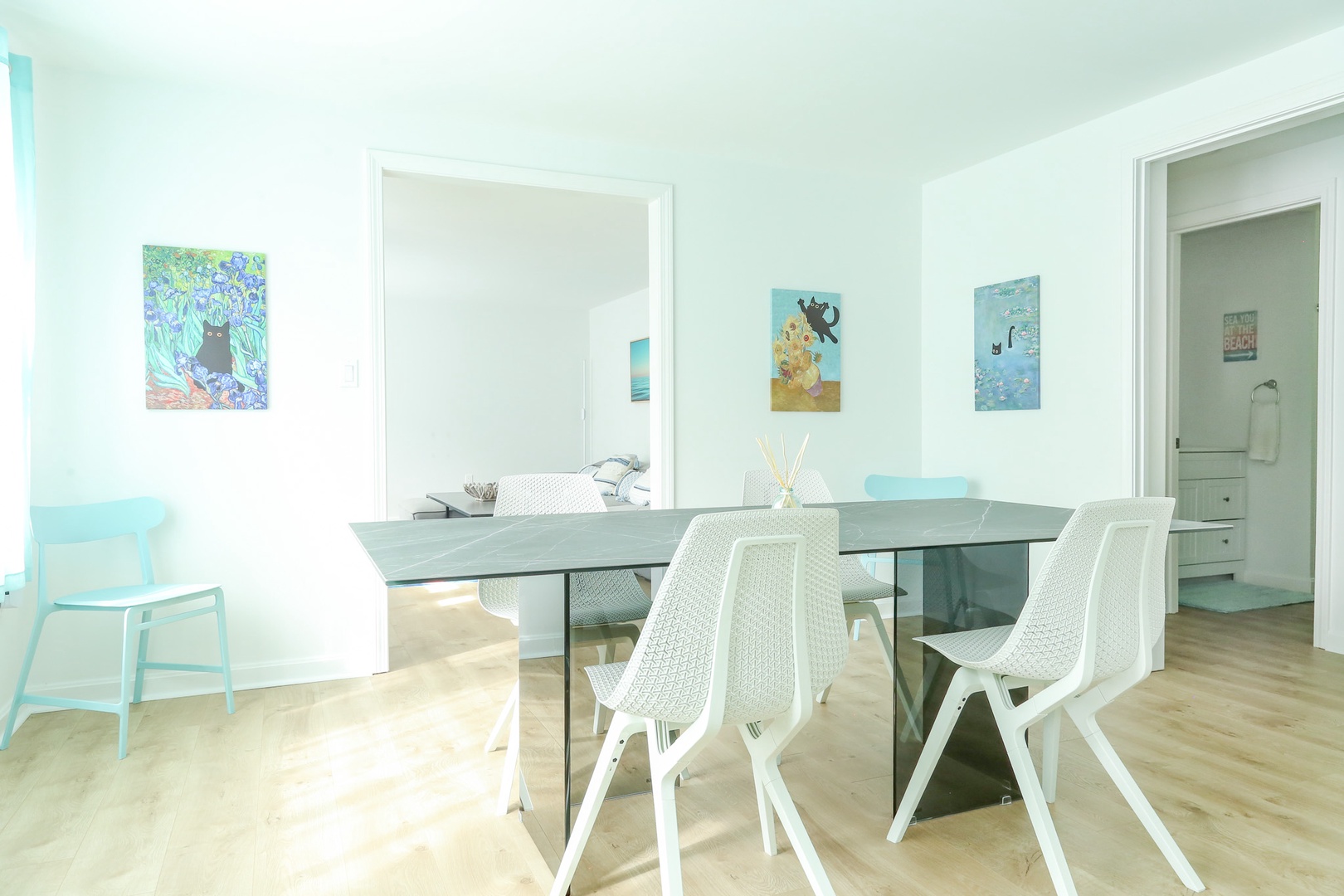 Gather around this sleek dining table, where the bright airy design and playful artwork create a welcoming space for your meals and conversations together.