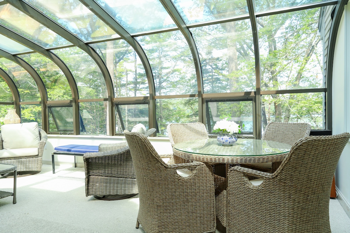 Bask in natural light beneath the curved glass ceiling while you sip your morning coffee surrounded by lush forest views—a serene retreat that blurs the line between indoors and out.