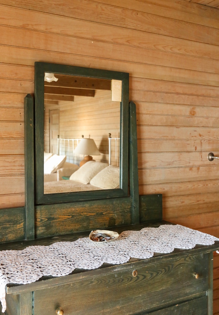 Step into your charming bedroom where rustic wood meets cozy comfort, complete with vintage furnishings and soft linens awaiting your arrival.