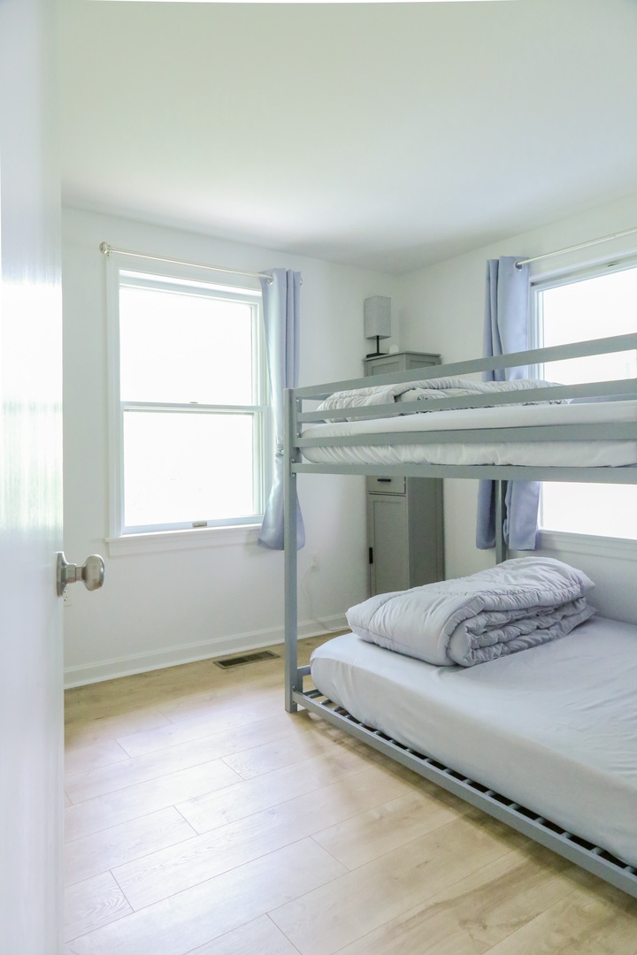 Your bright, airy bedroom features a space-saving bunk bed with crisp linens, perfect for families or groups looking to maximize comfort while keeping everyone close.