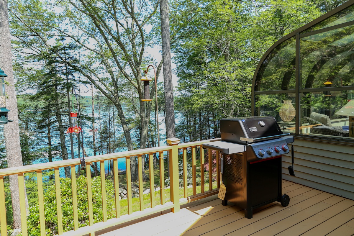 Fire up the grill on your private deck and soak in stunning waterfront views through towering trees—your perfect spot for outdoor dining and relaxation.