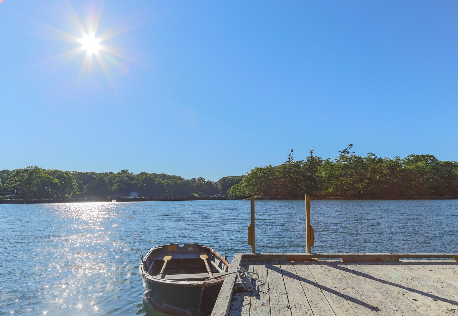 Sparkling waters and a private dock await, framed by lush shoreline and endless blue skies—perfect for peaceful mornings on the water.