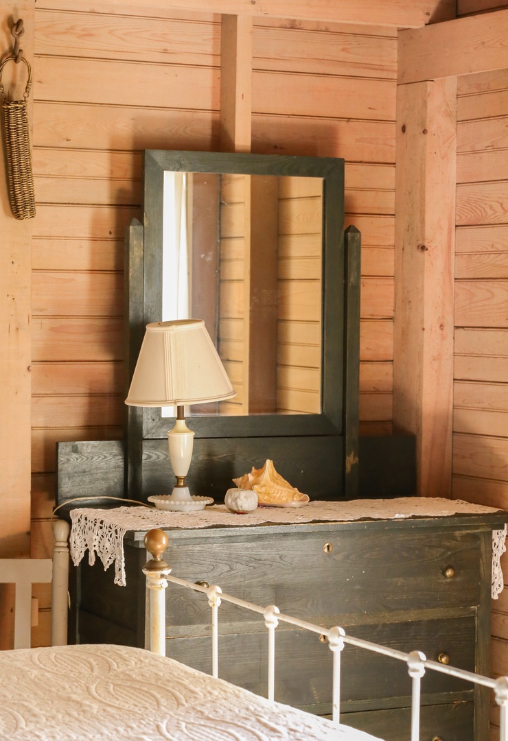 Unwind in your rustic bedroom featuring charming wooden walls and vintage furnishings that create a cozy retreat.