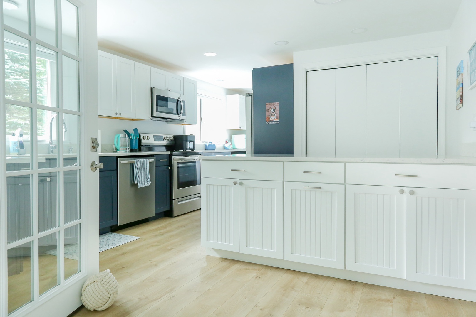 Step into your bright, fully equipped kitchen with modern appliances and plenty of counter space for preparing meals. The airy coastal design and abundant natural light make cooking feel effortless.