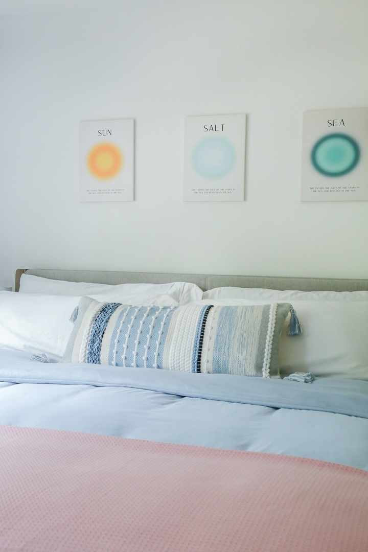 Unwind in your airy coastal bedroom, where soothing blue linens and soft pastels invite you to drift off to sleep.