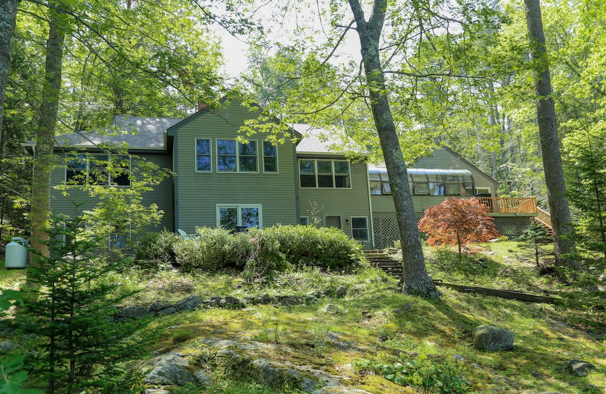 A charming retreat nestled in the woods, where sunlight filters through tall trees and lush greenery surrounds your private getaway. The natural moss-covered landscape and mature forest create a peaceful escape from everyday life.