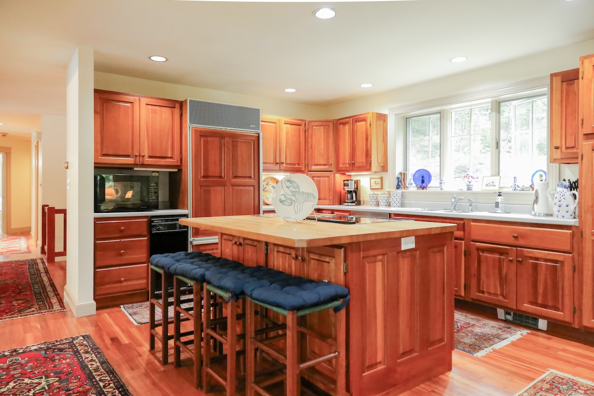Your dream kitchen awaits with rich wood cabinetry, stainless appliances, and a spacious island perfect for meal prep or casual dining. Natural light floods through large windows, creating a warm and inviting space.