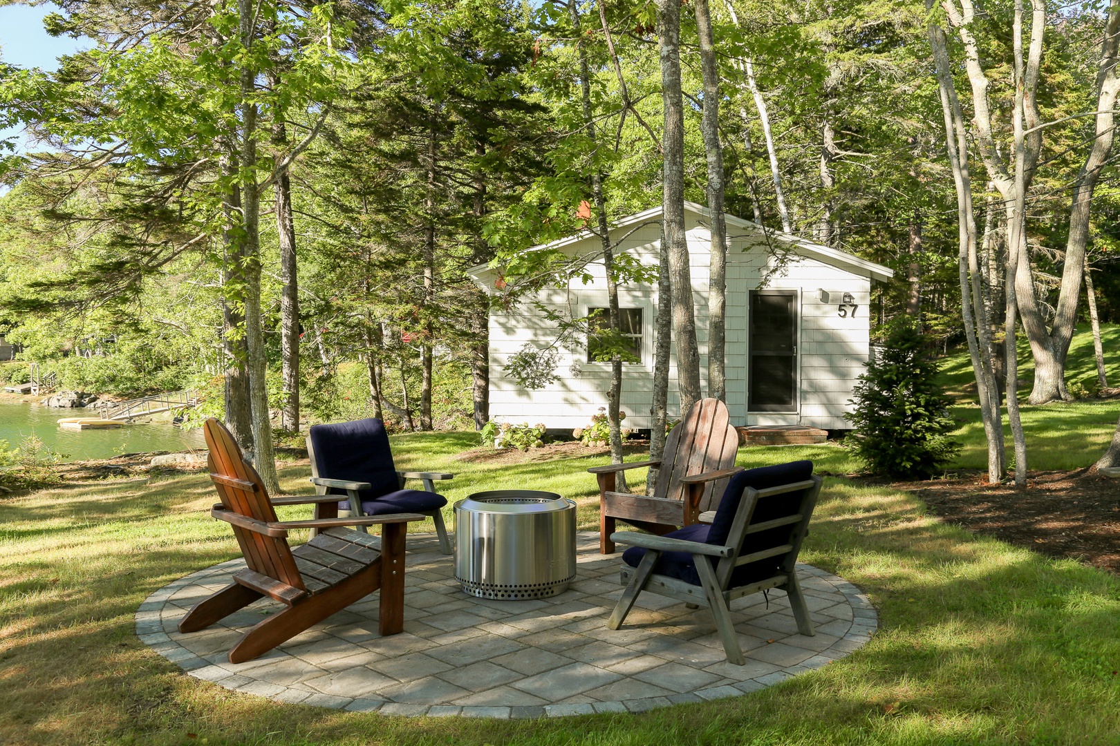 Your private retreat is nestled among tall pines, with a cozy fire pit seating area perfect for evening gatherings under the trees.