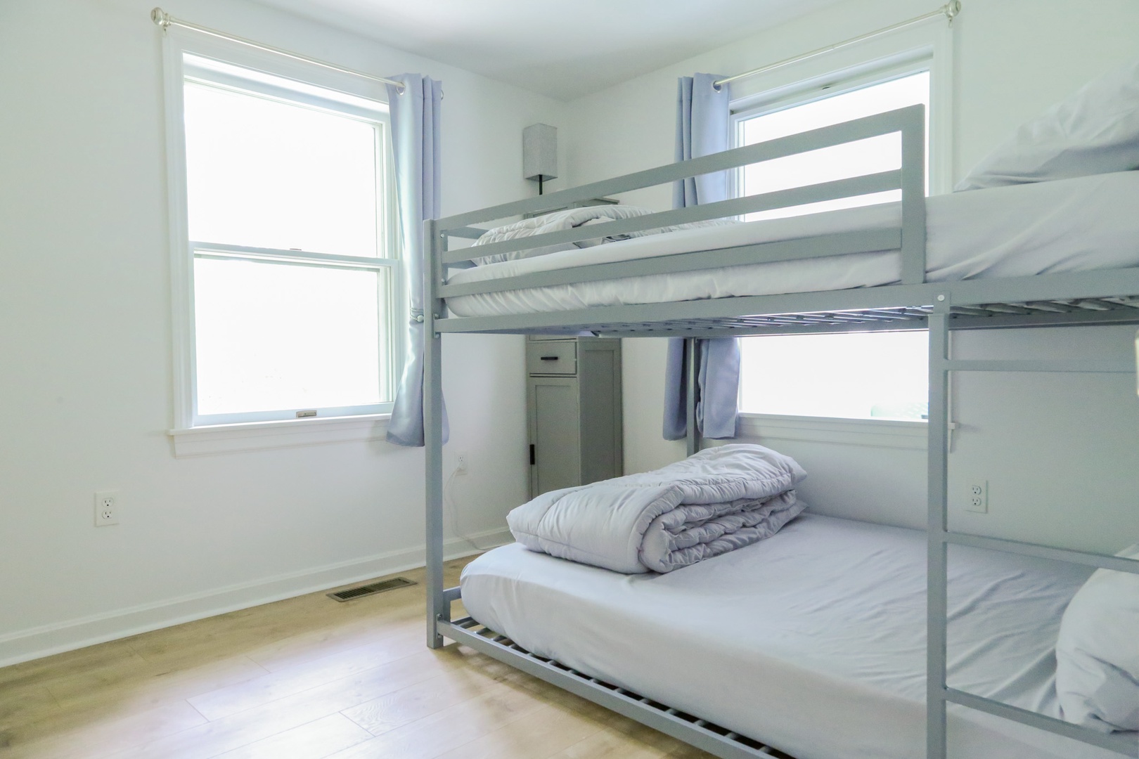 Light-filled sleeping quarters with full bunk beds dressed in soft linens. Perfect for families or groups, this cozy room offers plenty of natural light and a peaceful retreat after your day's adventures.