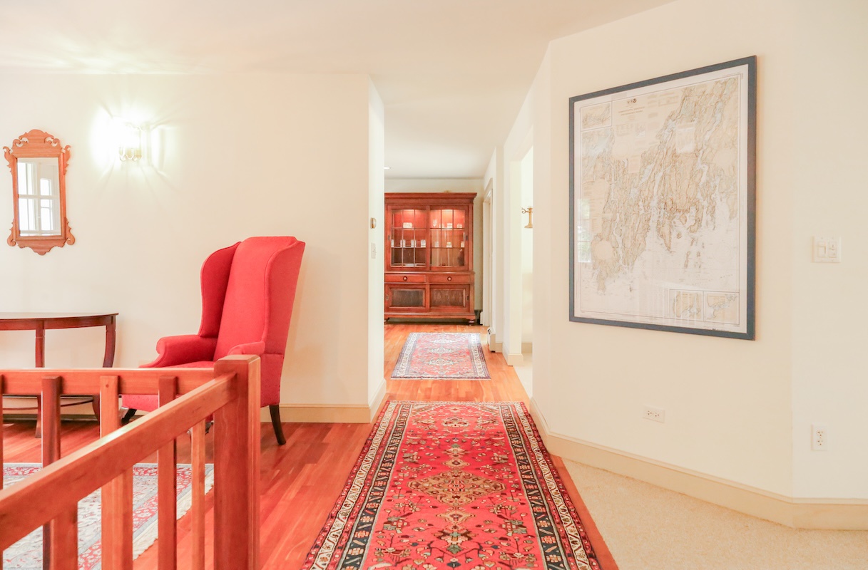 Step into your private hallway where warm wood floors meet colorful rugs and elegant furnishings, guiding you through this thoughtfully designed space that feels both historic and welcoming.