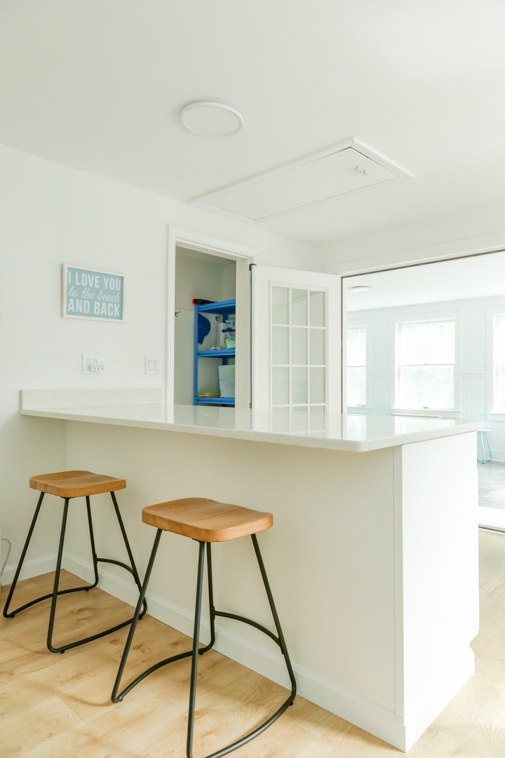 Gather around this inviting breakfast bar with modern stools, perfect for your morning coffee or casual meals while soaking in the bright, airy ambiance.