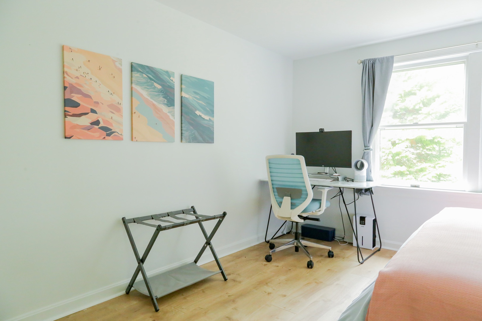 Your peaceful workspace with a desk by the window and soothing coastal artwork to inspire relaxation during your stay.
