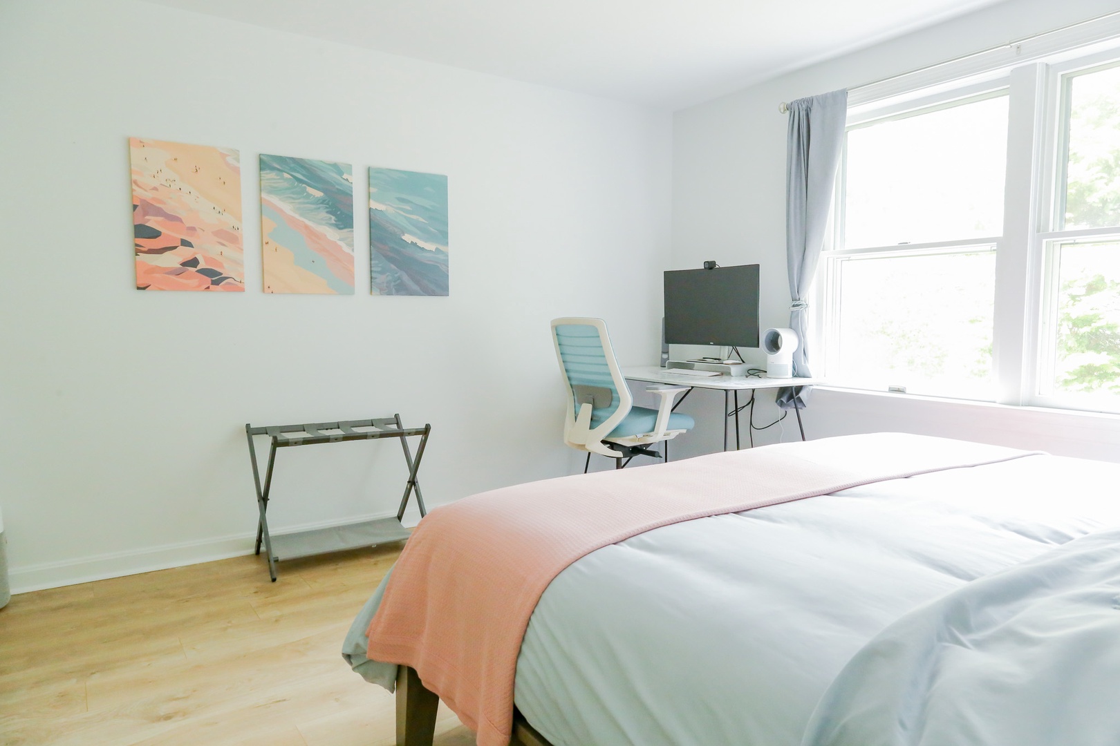Step into your bright and peaceful bedroom with soothing coastal tones, soft linens, and a dedicated workspace by the sunny window—your perfect retreat for rest and productivity.