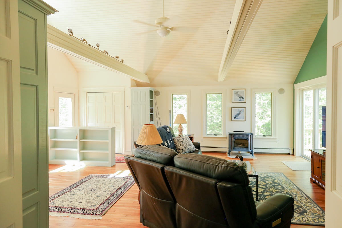 Settle into your airy living room with vaulted ceilings, cozy leather seating, and soft natural light filtering through multiple windows. The warm wood floors and peaceful ambiance invite you to unwind completely.