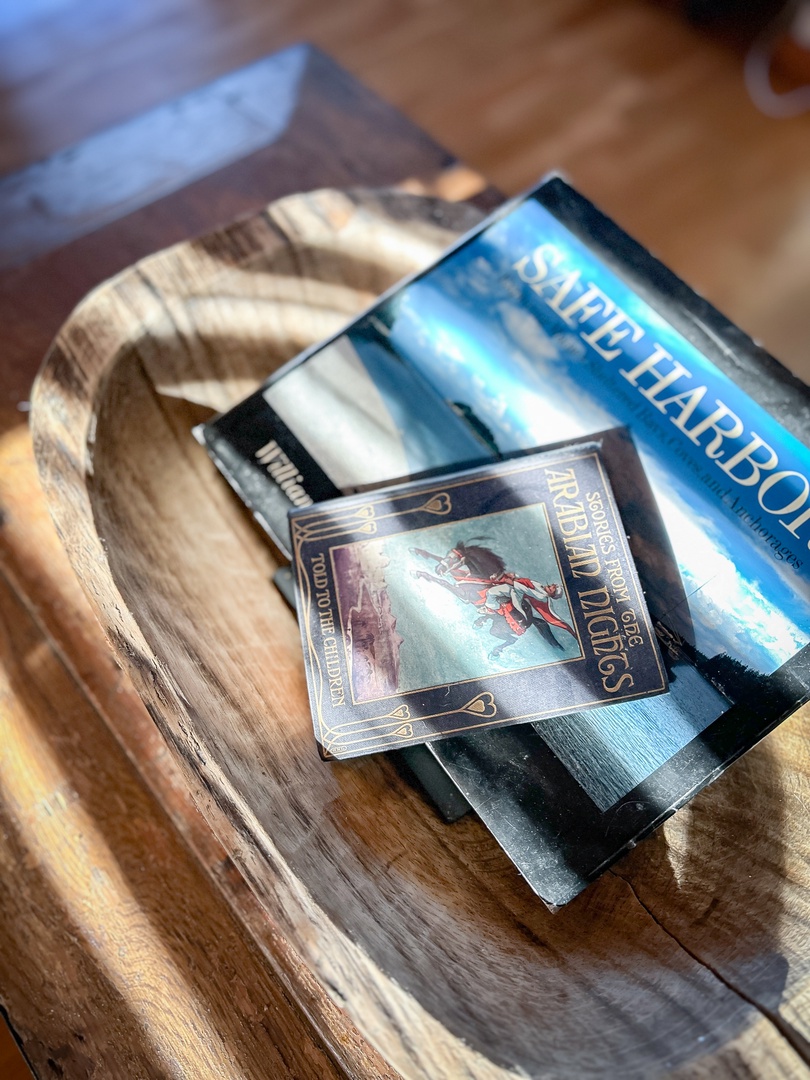Cozy reading nook with books and magazines on rustic wooden table - perfect for your quiet moments.