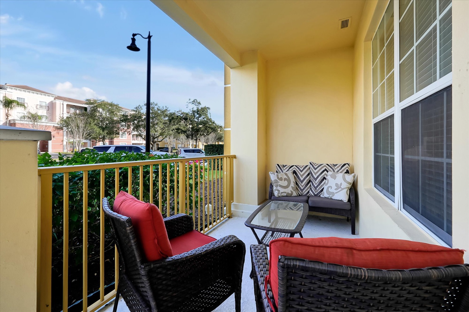 Unwind on your private balcony with comfortable wicker seating and colorful cushions, perfect for morning coffee or evening relaxation.