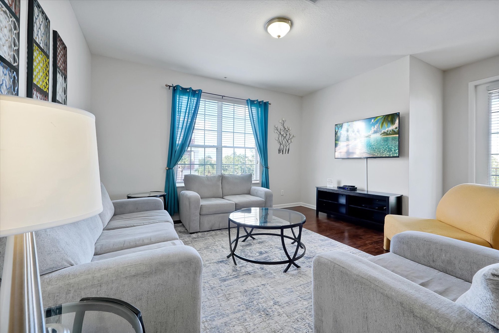 Relax in your bright living space with plush seating, streaming TV, and cheerful turquoise accents that create a welcoming atmosphere.