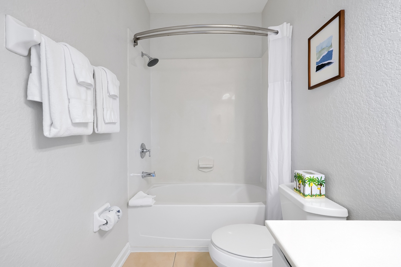 Step into your pristine private bathroom featuring a relaxing tub-shower combo, fluffy towels, and thoughtful amenities for your comfort.