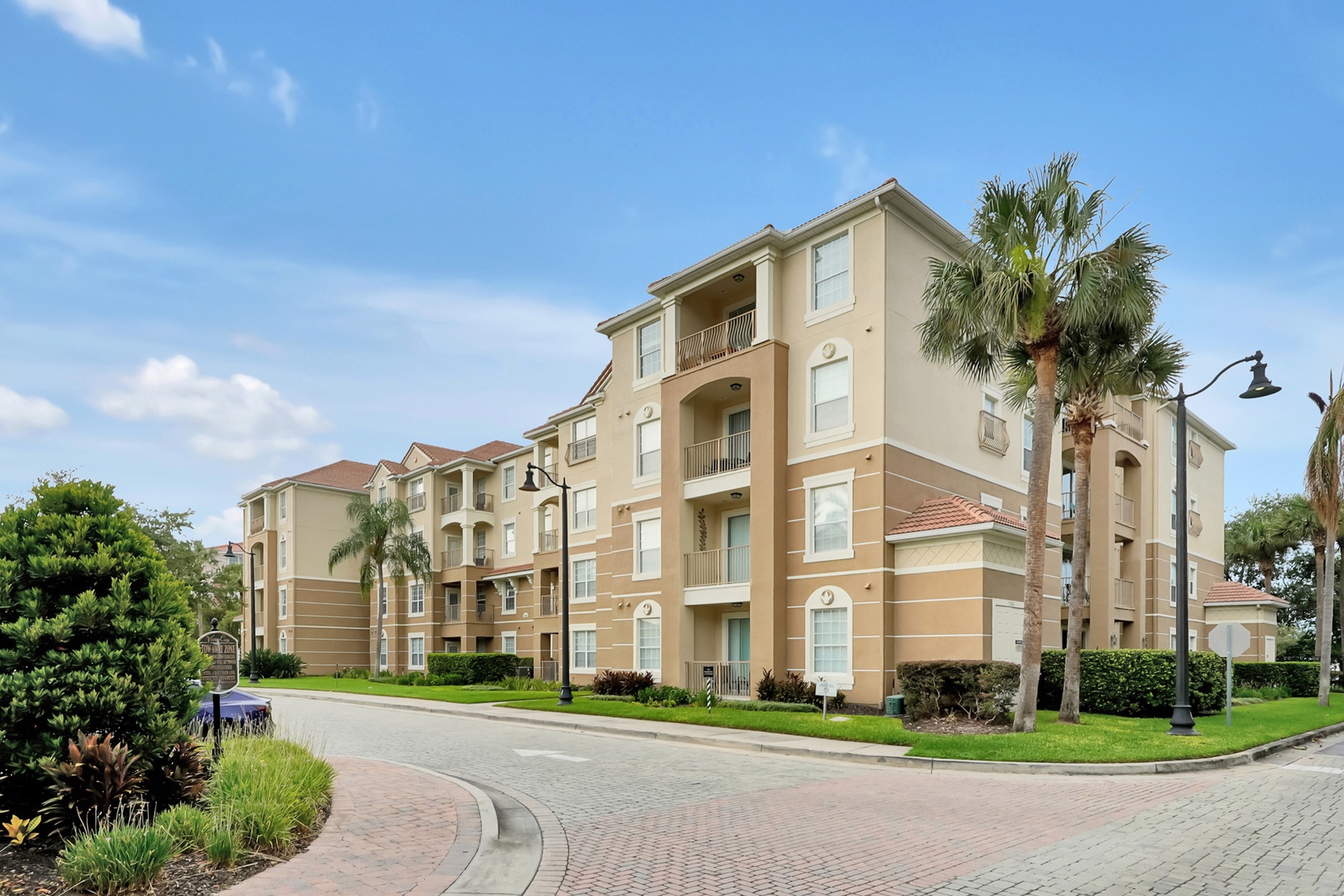 Located in building 5000, right next to the clubhouse. The property is located in a well-maintained residential complex with Mediterranean-style architecture and beautifully landscaped grounds featuring tropical palm trees and manicured lawns.