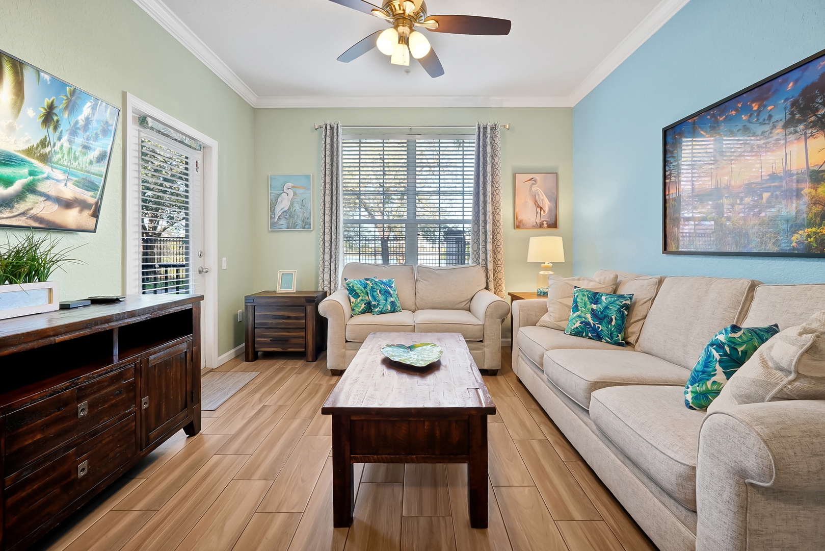 Relax in your coastal-themed living room with plush seating, tropical accents, and artwork that brings beach vibes indoors.