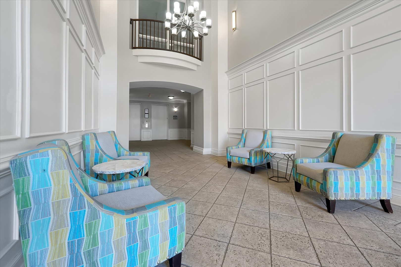 Step into this elegant lobby where coastal-inspired seating and soaring ceilings create your perfect welcome home.