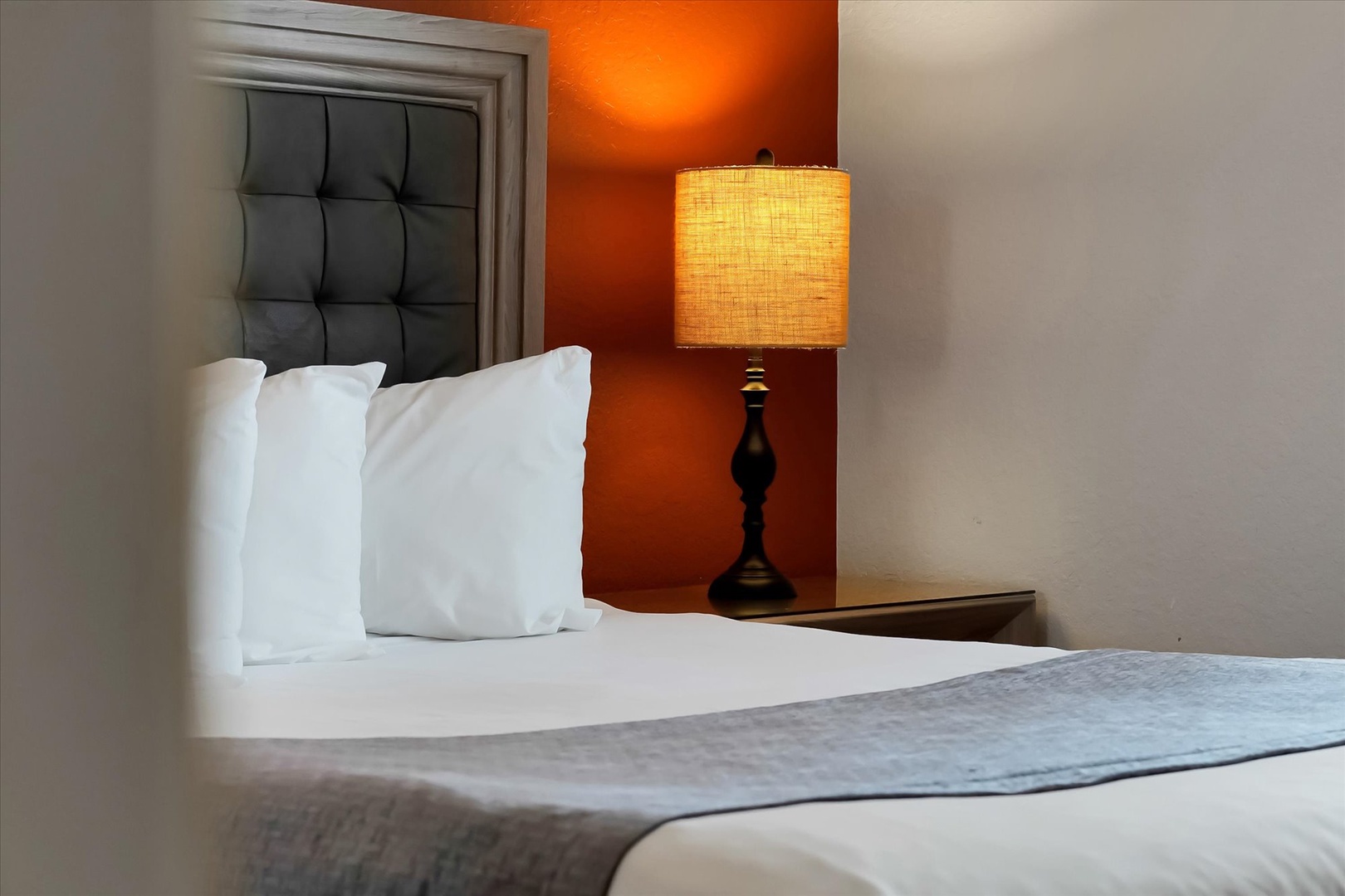 Sink into plush bedding beneath warm accent lighting that creates the perfect ambiance for your restful evening retreat.