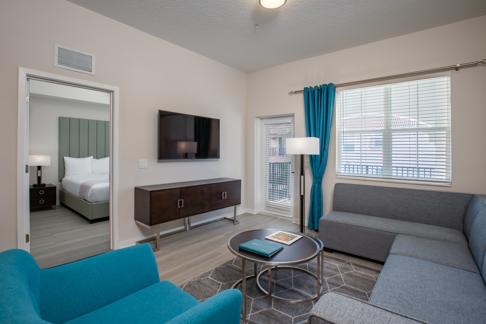 Unwind in your stylish living space with modern furnishings and vibrant turquoise accents creating the perfect atmosphere for relaxation.