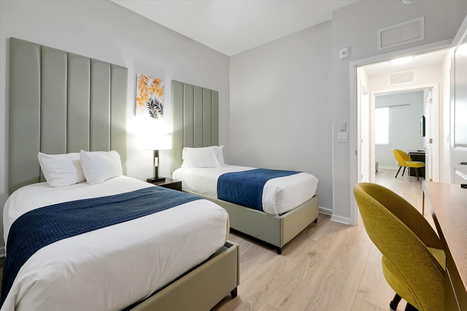 Sink into crisp white linens in your stylish twin bedroom with sage headboards and modern comfort touches.