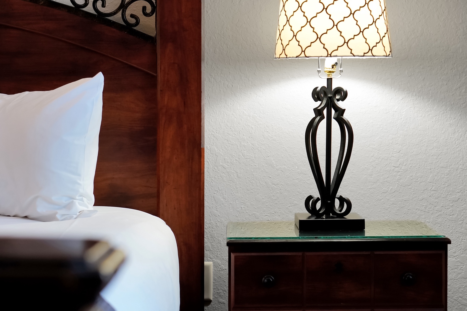 Sink into crisp linens and rest your head on fluffy pillows. A stylish bedside lamp casts a warm glow, creating the perfect ambiance for your evening wind-down.
