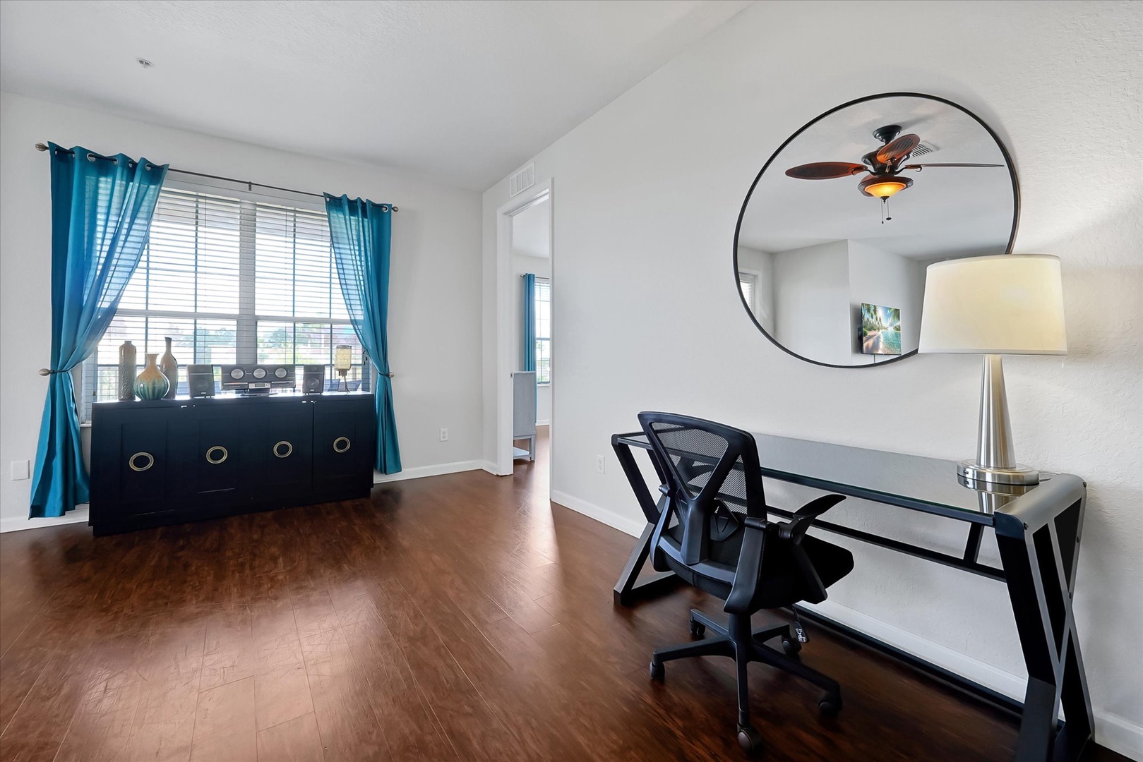 Your private workspace awaits with sleek glass desk, ergonomic chair, and natural light from expansive windows.