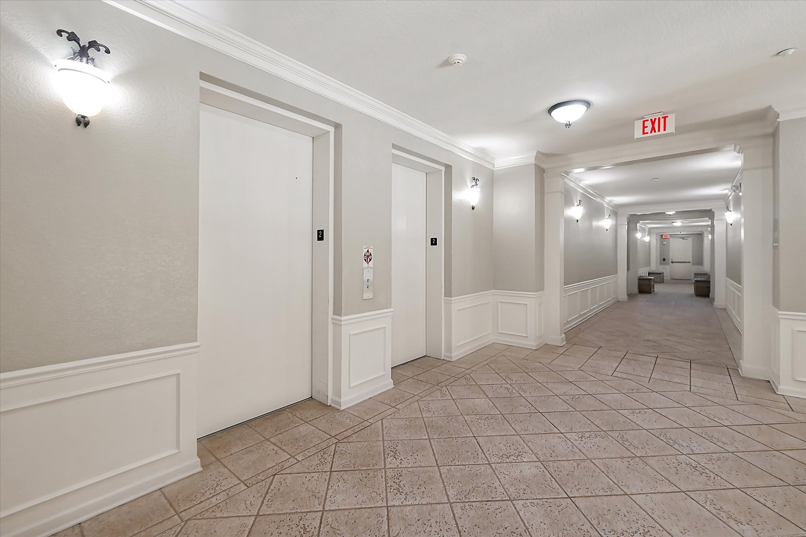 Elegant hallway with classic white wainscoting and warm lighting leads you to your comfortable accommodations.