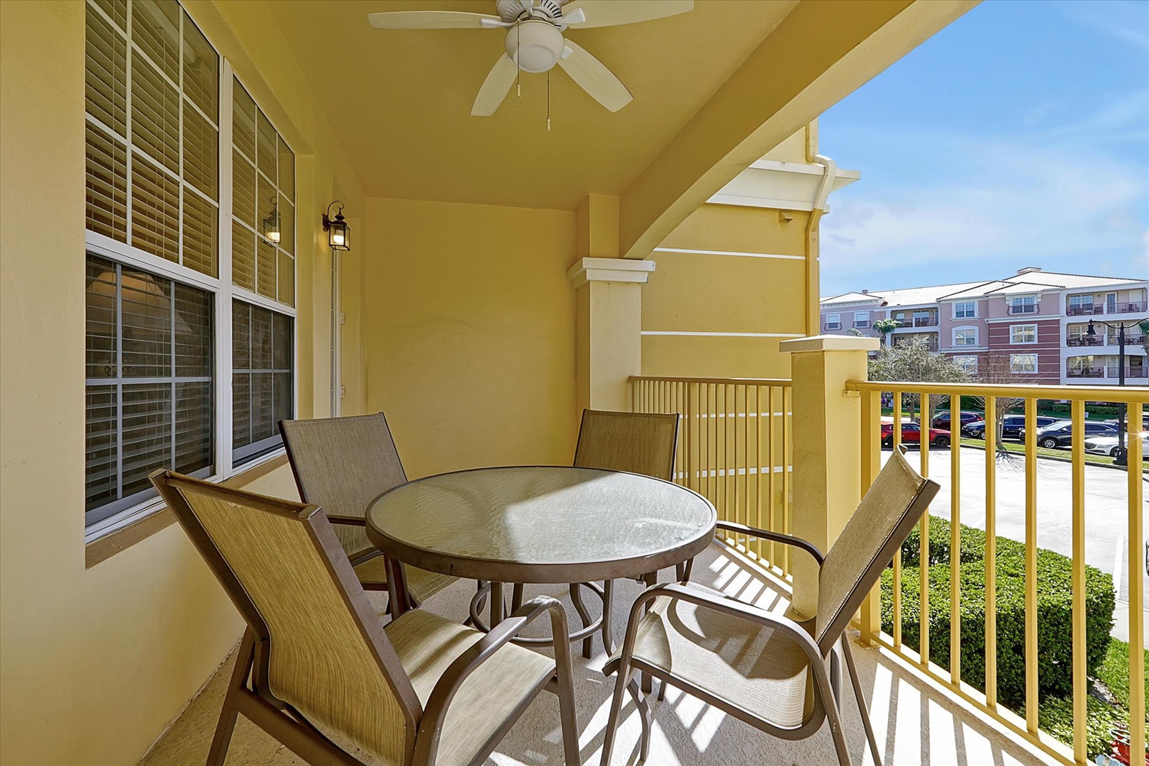 Unwind on your private balcony with comfortable seating for four, ceiling fan overhead, and peaceful neighborhood views stretching before you.