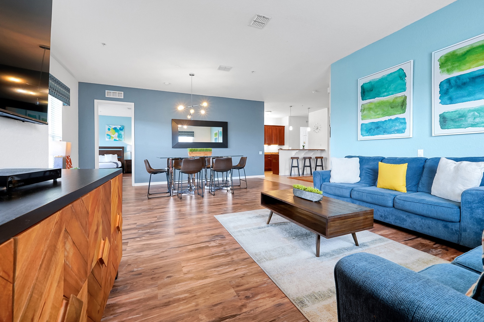 Step into your bright, open living space where ocean-inspired accents and warm wood floors create the perfect coastal retreat for gathering with family or unwinding after a day of adventure.
