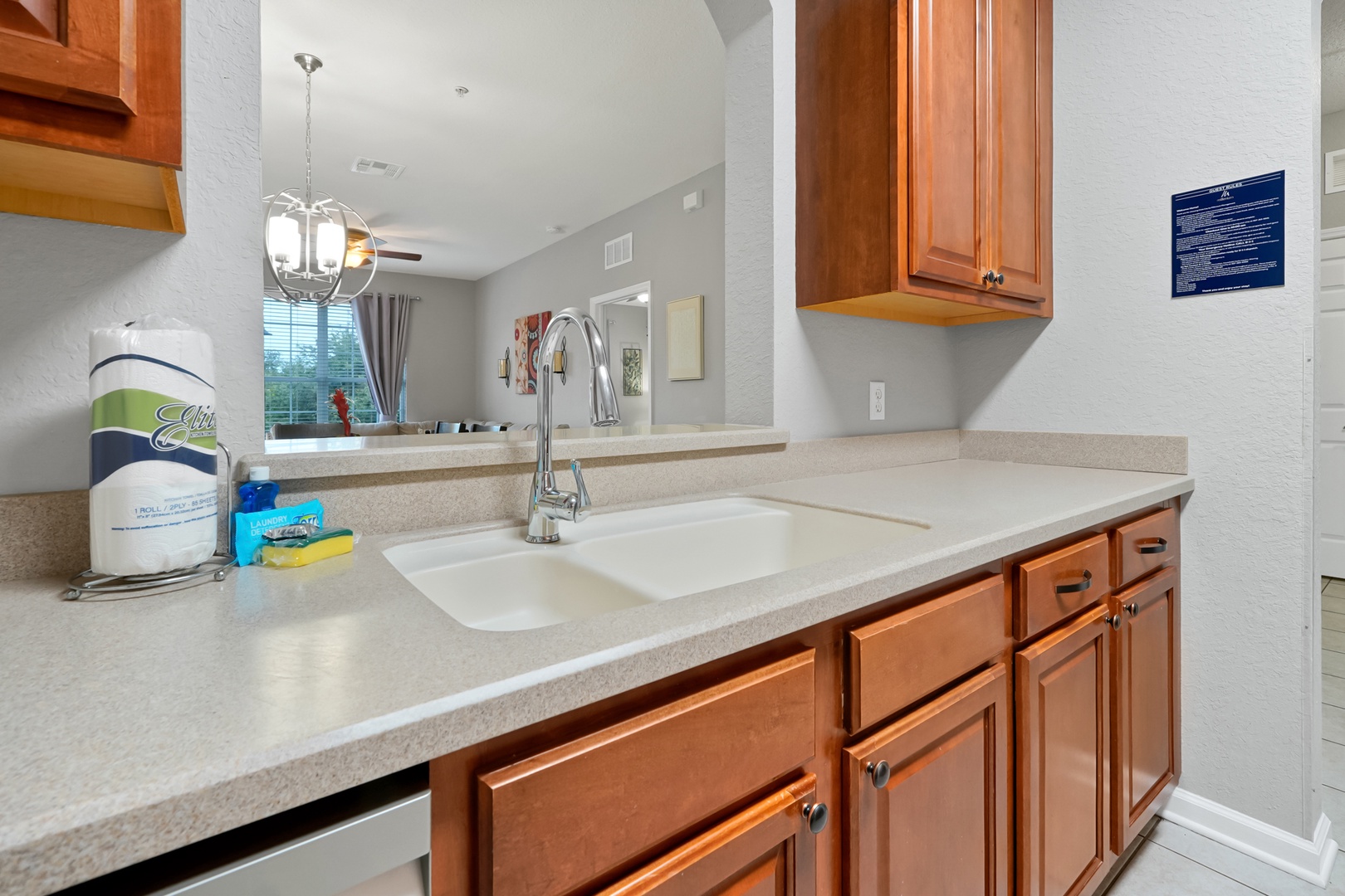 Your full kitchen invites you to prepare meals with ease, featuring warm wood cabinetry, ample counter space, and a double sink that looks out into the bright living area.