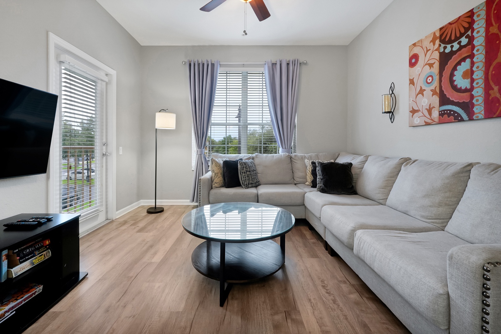 Sink into the plush sectional and unwind in your bright, inviting living room, where natural light streams through the French doors and a vibrant splash of color adds personality to the space.