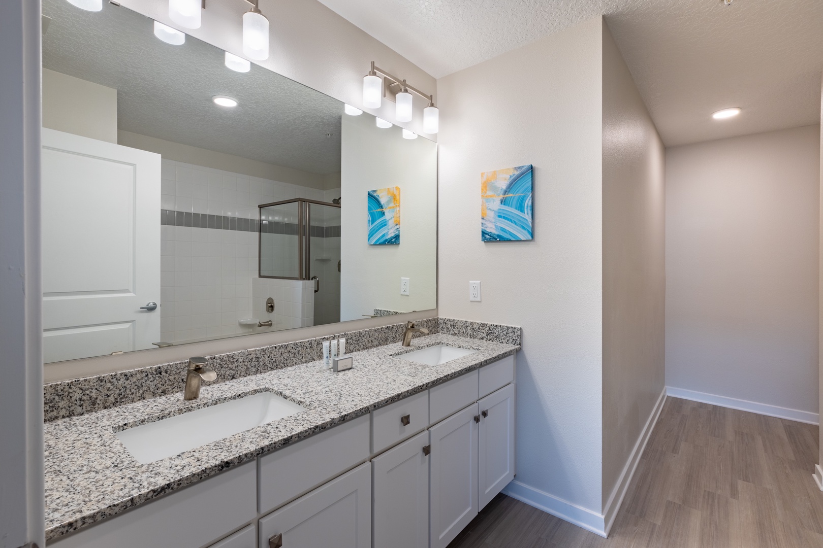 Step into your bright bathroom featuring granite counters, modern vanity lighting, and a sleek glass shower for your daily refresh.