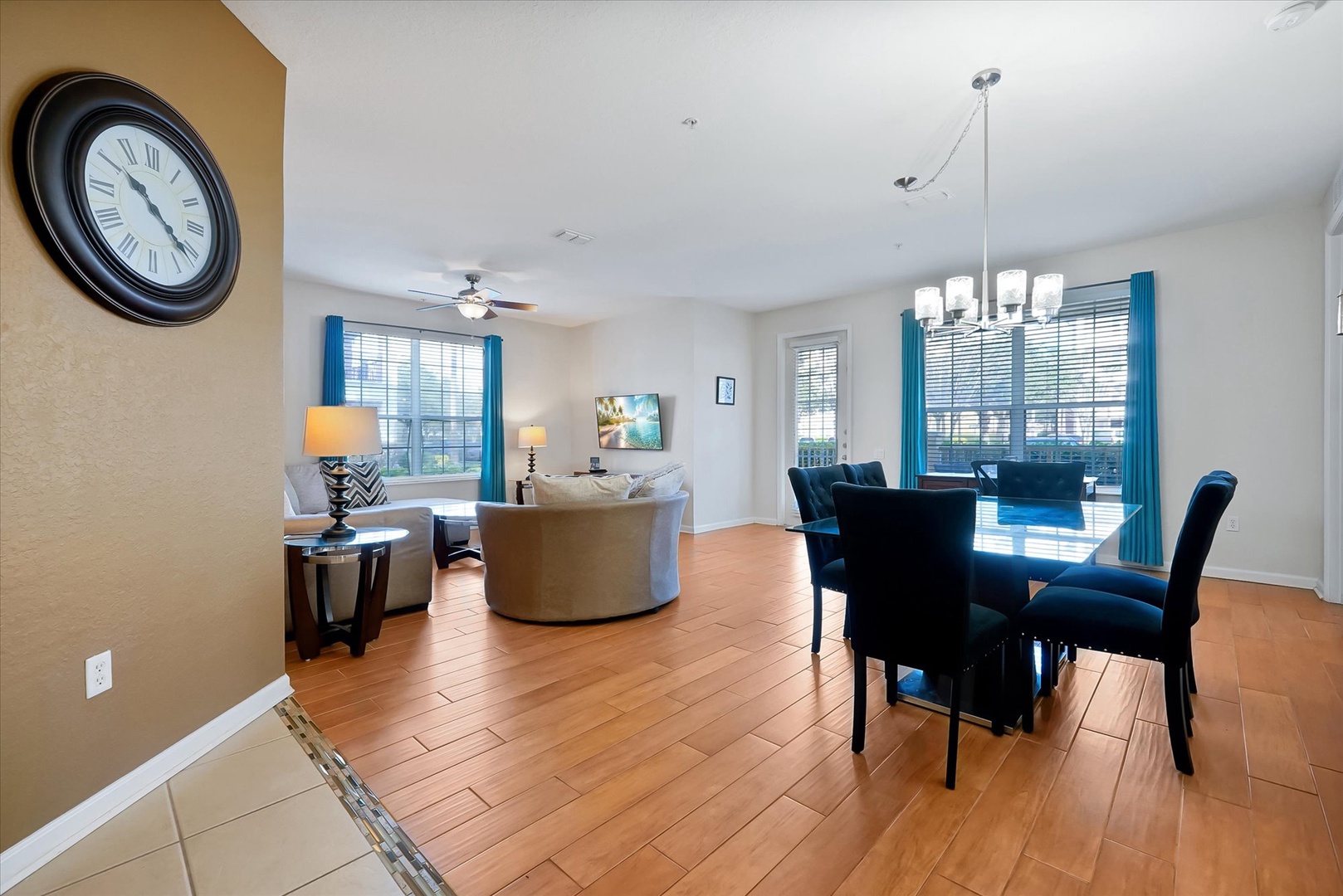 Relax in your spacious open-concept living and dining area, where warm hardwood floors and bright turquoise accents create a welcoming retreat.