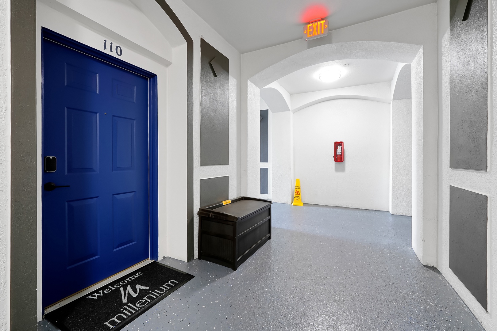 Step through your vibrant blue door into a clean, modern hallway with convenient storage space for all your travel essentials.