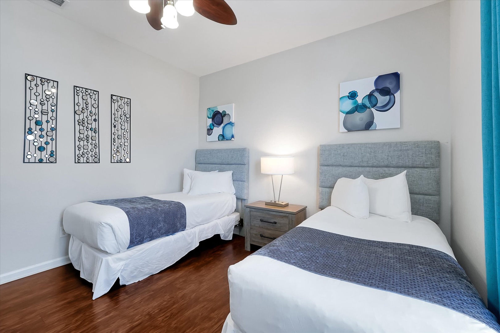 Rest comfortably in this stylish twin bedroom featuring plush beds with crisp linens and contemporary decor for a peaceful night's sleep.