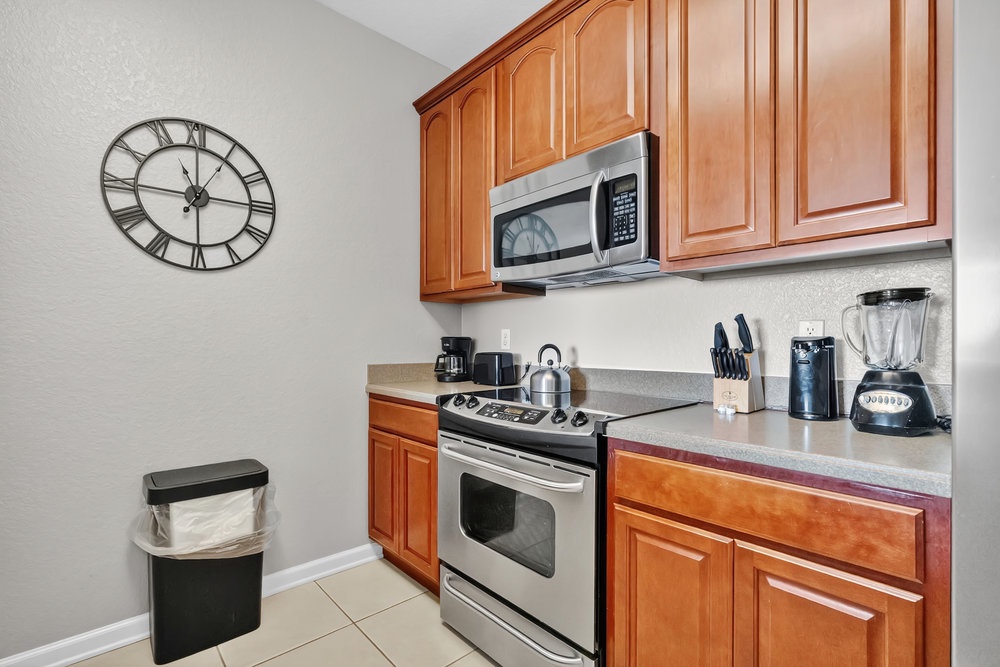 Your fully equipped kitchen awaits with warm wood cabinetry, granite counters, and modern appliances for preparing delicious meals during your stay.