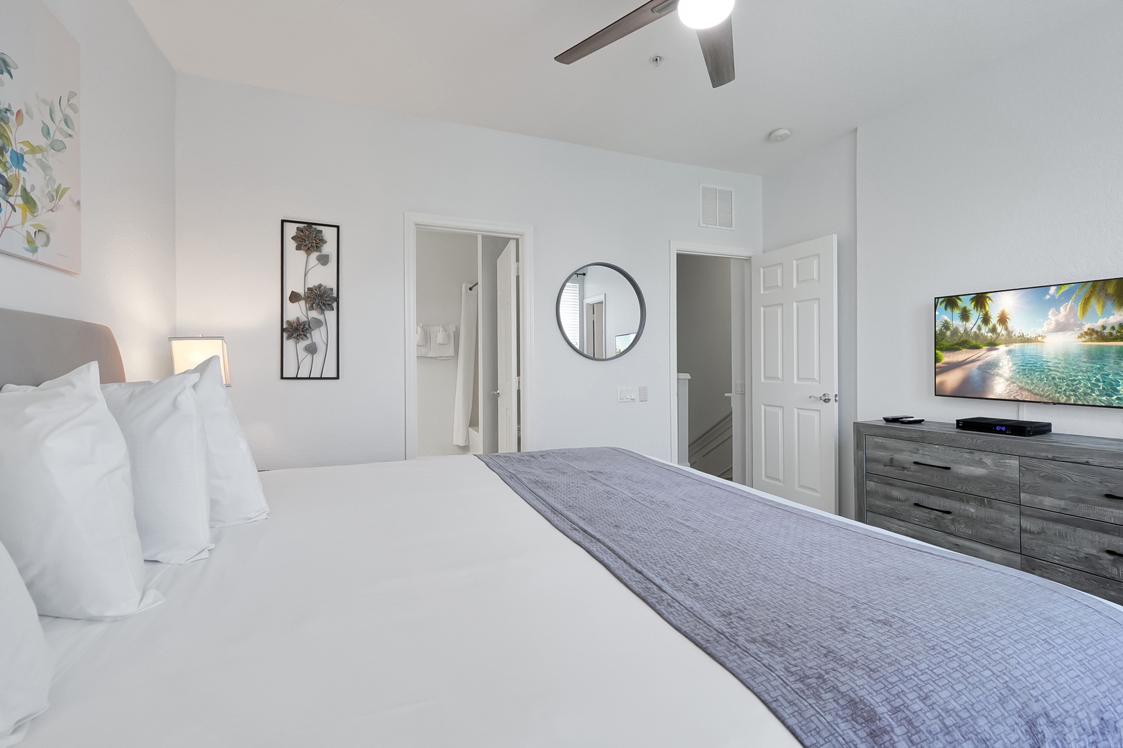 Unwind in your serene bedroom with crisp linens, modern amenities, and a peaceful beach scene on the smart TV to set your vacation mood.