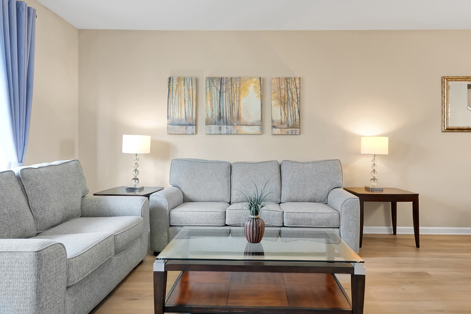 Sink into plush gray sofas in your bright living room, where elegant artwork and warm lighting create the perfect spot to unwind after exploring.