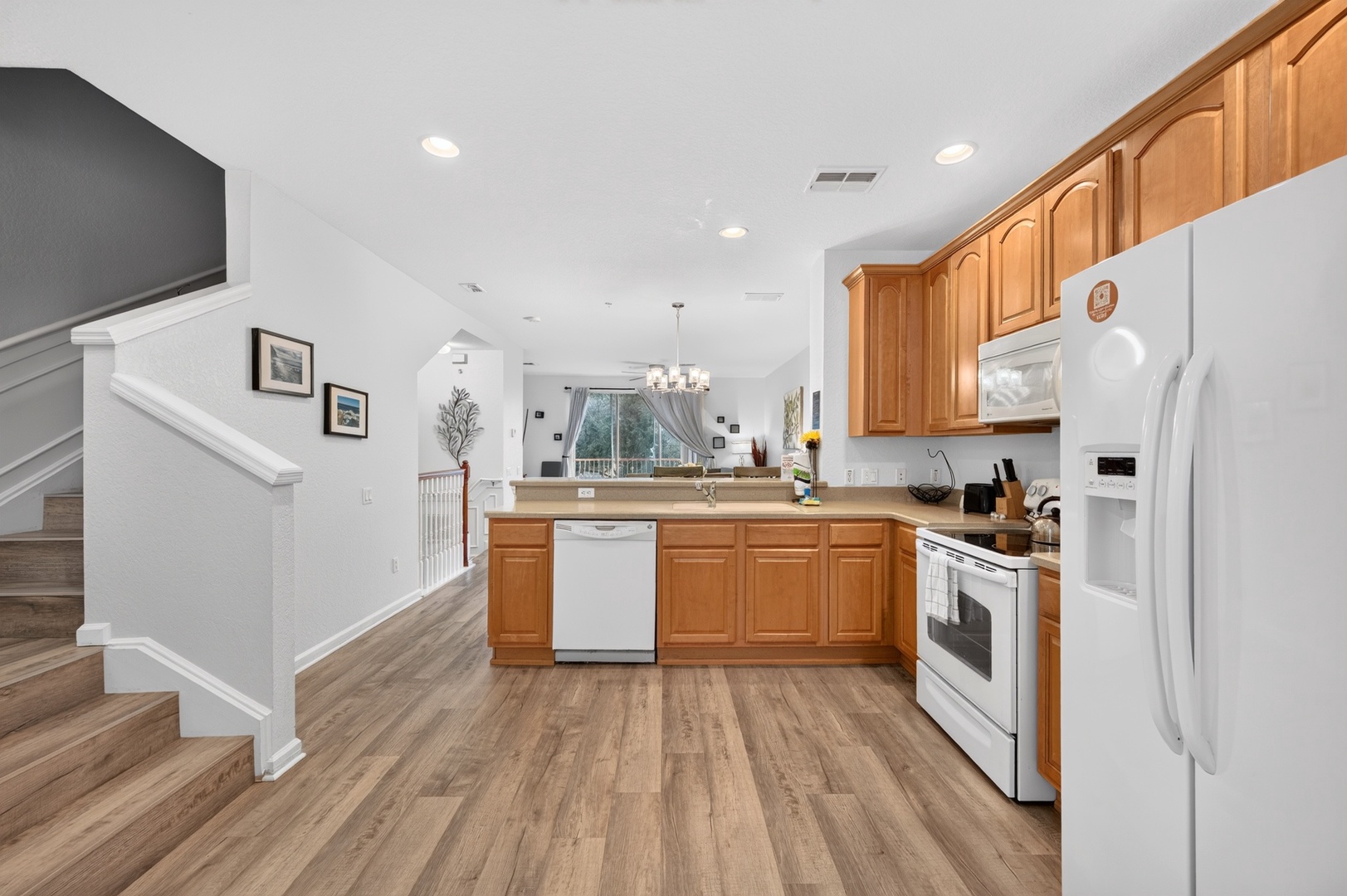 Your spacious kitchen features warm wood cabinetry, modern appliances, and plenty of counter space for meal prep. Natural light from the window makes cooking a delight.
