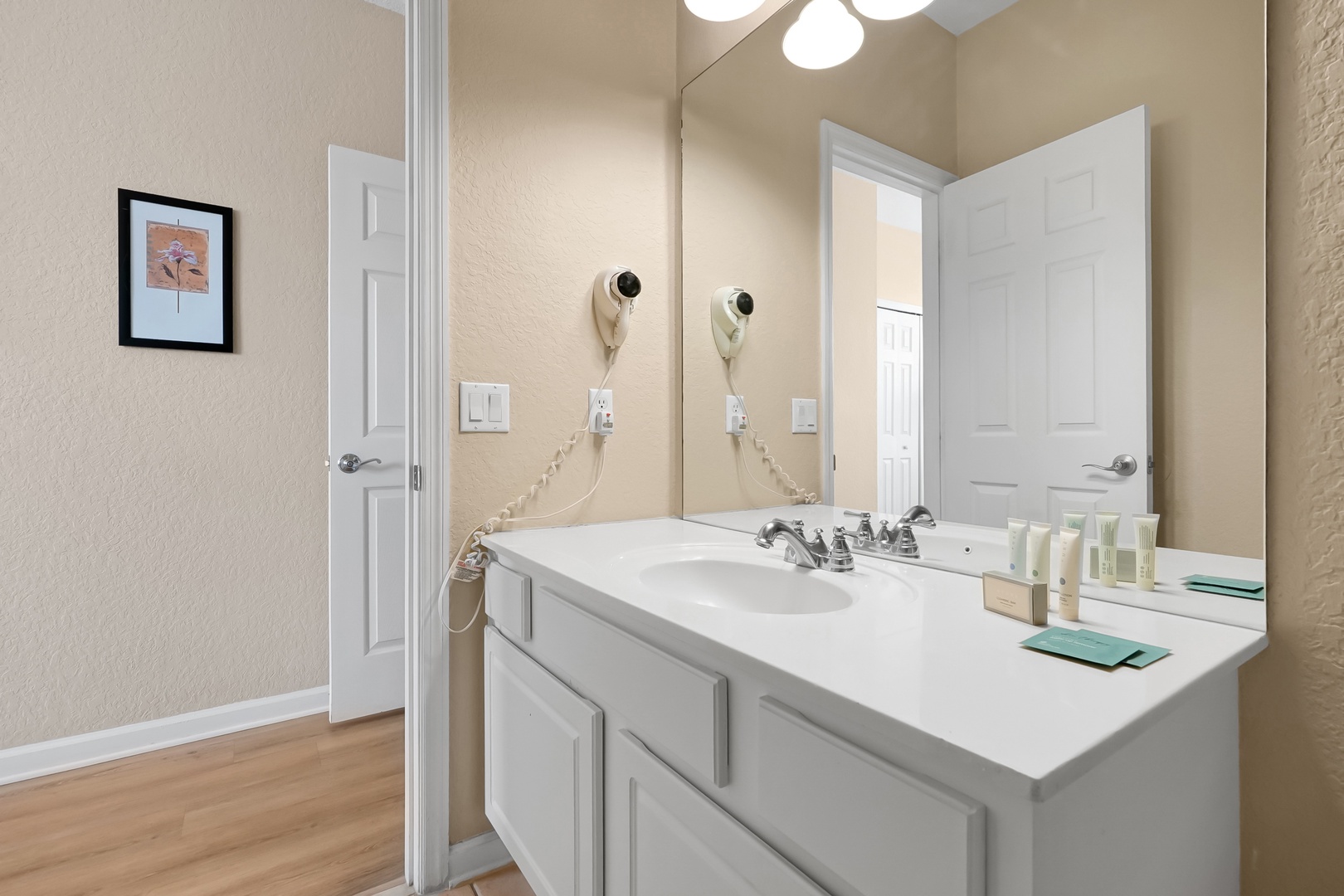Step into your pristine bathroom with a spacious vanity, perfect lighting, and thoughtful amenities like hair dryers ready for your morning routine.