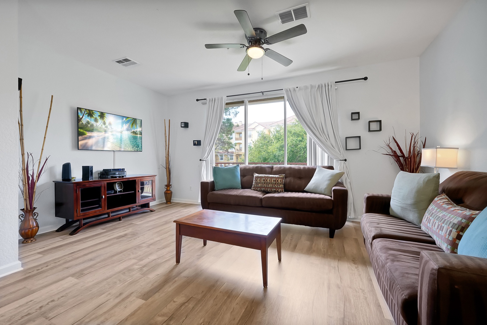 Unwind in your spacious living room with comfortable seating, entertainment center, and natural light streaming through large windows.