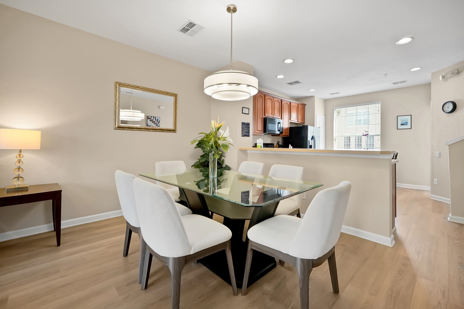 Gather around your elegant glass dining table for memorable meals, perfectly positioned between your modern kitchen and living space.