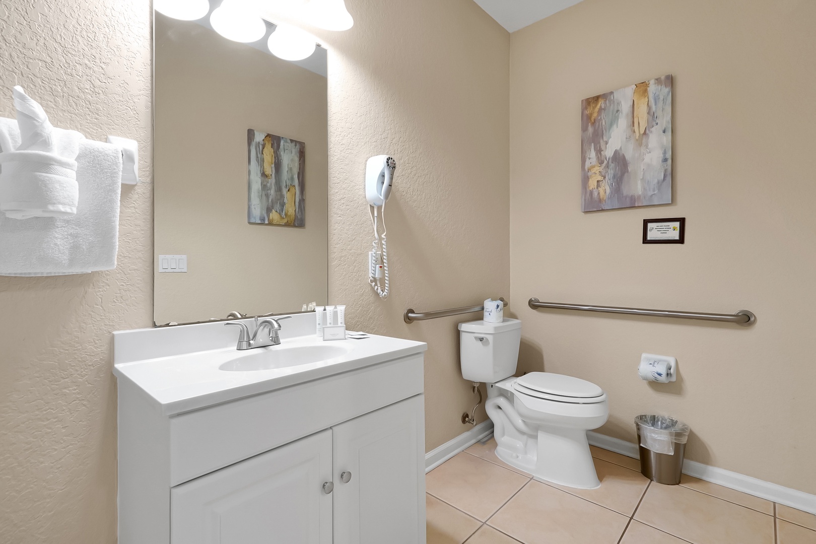 Your private bathroom features accessible grab bars, fresh linens, and thoughtful artwork for comfort and convenience.