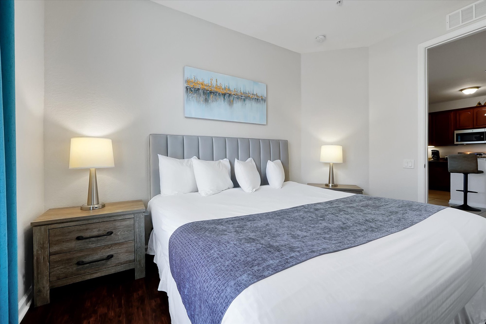 Sink into plush bedding with crisp white linens and elegant gray tufted headboard - your peaceful retreat awaits.