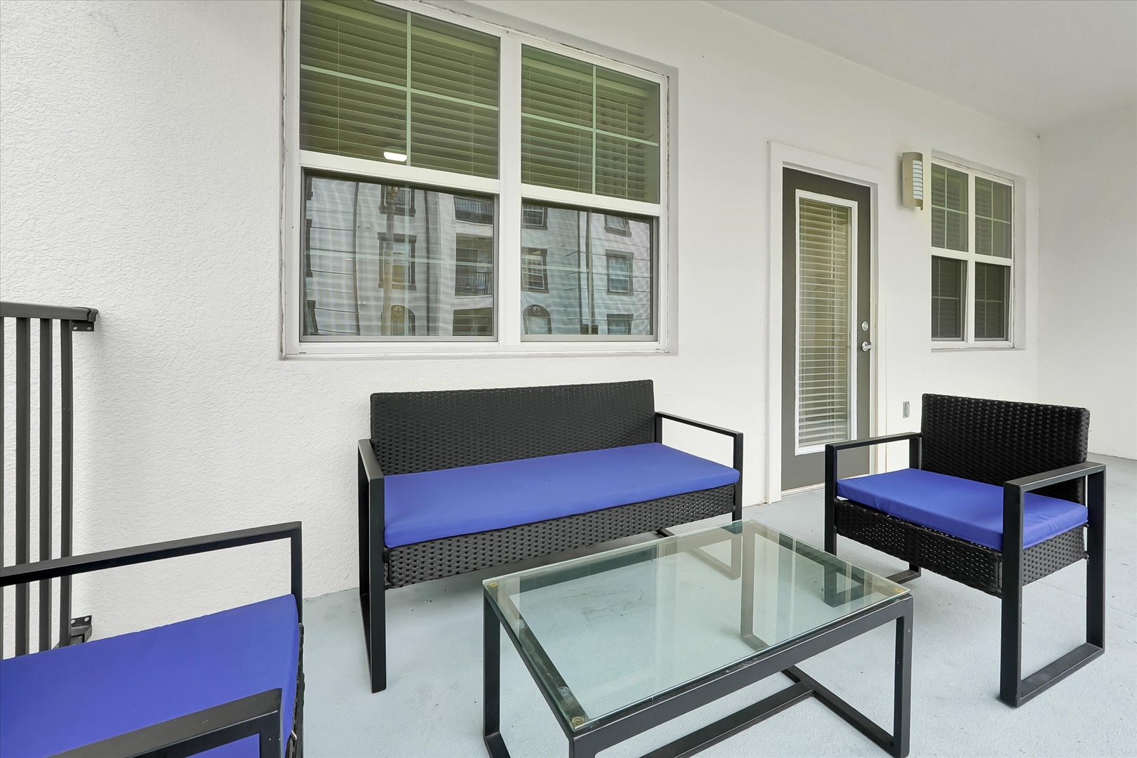 Relax on your private balcony with stylish wicker furniture and vibrant blue cushions, perfect for morning coffee or evening unwind.