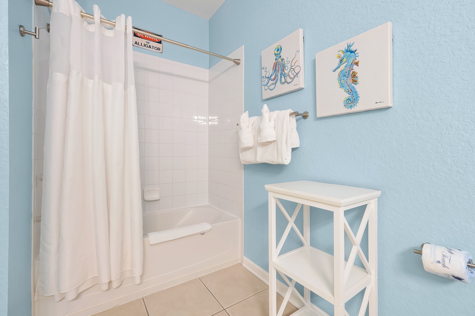 Refresh in your coastal-themed bathroom with sea life artwork, fluffy towels, and a soothing blue color palette that brings ocean vibes indoors.